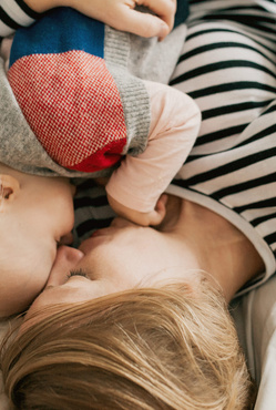 cute baby and mother cuddling on bed